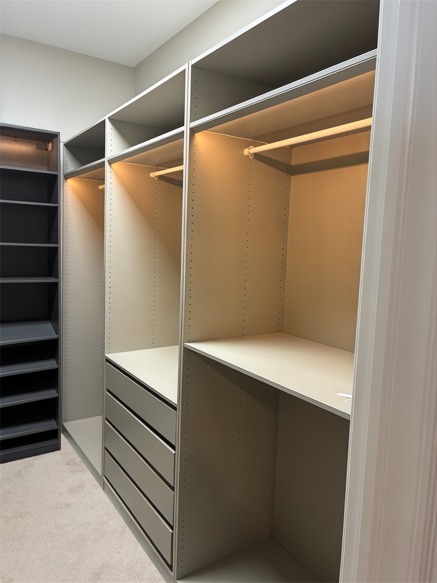 Modern Ikea walk-in closet with shelves and drawers in a neutral color scheme.